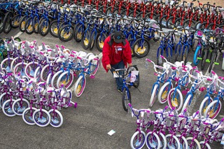 A volunteer moves donated bicycles during the 23rd annual KLUC 98.5-FM toy drive in the NV Energy parking lot on West Sahara Avenue Tuesday, Dec. 7, 2021. During the 12-day toy drive Chet Buchanan, lives on a platform in the parking lot.