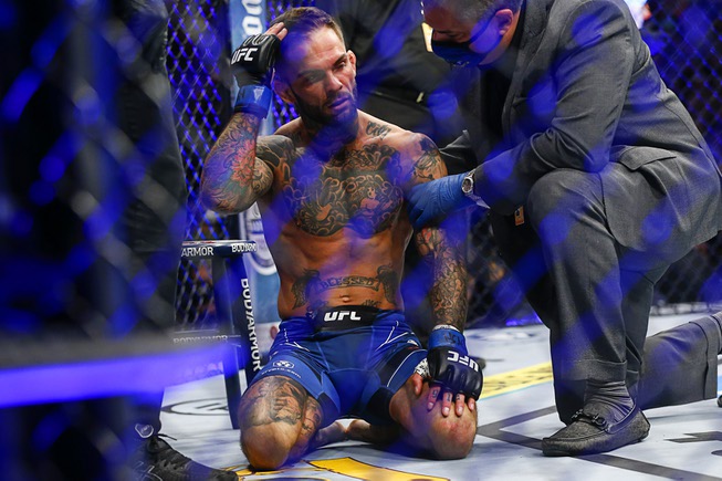 Cody Garbrandt, left, is checked by officials after being knocked out by Kai Kara-France in a flyweight mixed martial arts bout at UFC 269, Saturday, Dec. 11, 2021, in Las Vegas.