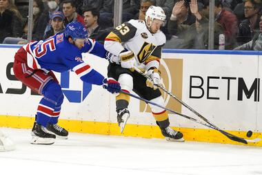 New York Rangers defenseman Libor Hajek (25) and Vegas Golden Knights right wing Evgenii Dadonov (63) fight for the puck during the second period of an NHL hockey game, Friday, Dec. 17, 2021, at Madison Square Garden in New York. (AP Photo/Mary Altaffer)

