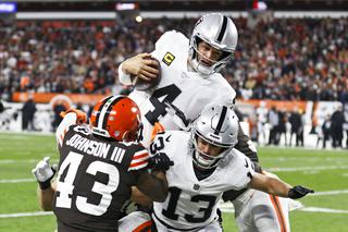 Las Vegas Raiders quarterback Derek Carr (4) tries to jump over Cleveland Browns strong safety John Johnson (43) during the first half of an NFL football game, Monday, Dec. 20, 2021, in Cleveland. Hunter Renfrow (13) tries to block Johnson out.