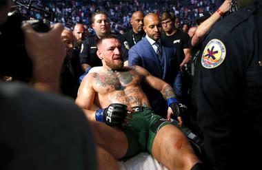 Conor McGregor is taken from the Octagon in a stretcher after breaking his leg in the first round of his fight against UFC lightweight champion Dustin Poirier during UFC 264 at T-Mobile Arena July 10, 2021. Due to the COVID-19 pandemic, UFC 264 was the first time since March 2020 that T-Mobile Arena hosted a UFC event with a full capacity crowd attending. REUTERS/