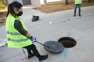 Lab technician Liz Dahlmann removes a manhole cover at UNLV during a demonstration of how wastewater samples are collected Tuesday, Jan. 11, 2022.
