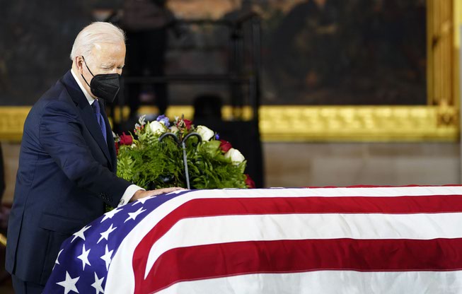President Joe Biden touches the flag-draped casket of former Senate ...