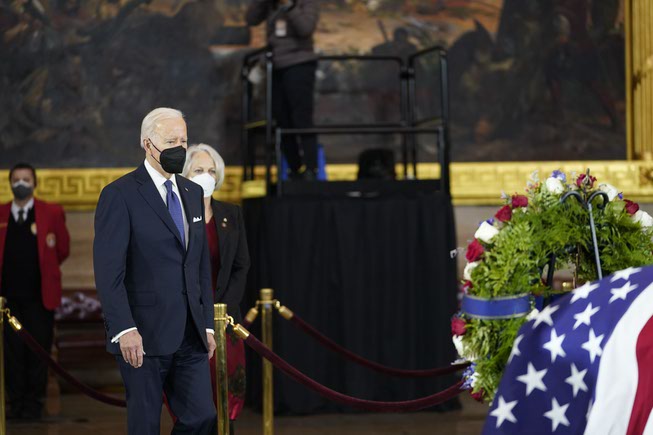 President Joe Biden arrives at the flag-draped casket of former ...