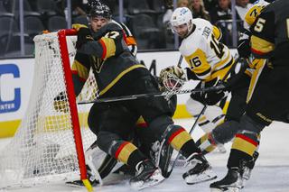 Vegas Golden Knights defenseman Ben Hutton (17) gets knocked into the goal as Pittsburgh Penguins left wing Jason Zucker (16) makes a shot past Vegas Golden Knights goaltender Robin Lehner (90) during the second period of an NHL hockey game at T-Mobile Arena Monday, Jan. 17, 2022.