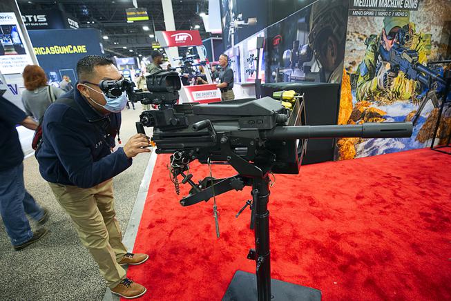 An attendee looks over a 40mm grenade launcher on display at the LMT Defense booth during the 2022 SHOT (shooting, hunting and outdoor trade) Show at the Venetian Expo Wednesday, Jan. 19, 2022.