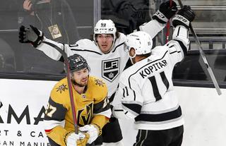 Vegas Golden Knights defenseman Shea Theodore (27) skates away as Los Angeles Kings defenseman Sean Durzi (50) and center Anze Kopitar (11) celebrate a 4-3 overtime win in overtime at T-Mobile Arena Friday, Feb.18, 2022.