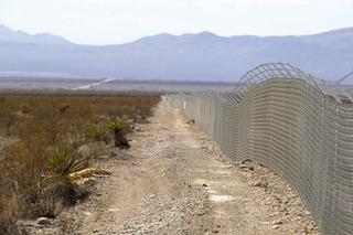 A fence marks the eastern edge of the Yellow Pine solar energy project along Tecopa Road, east of Pahrump, Nev. Tuesday, Feb. 22, 2022. Some conservation groups are protesting solar and wind projects because of the loss of habitat for desert species, as well as cultural losses for nearby tribes.