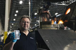 Sunshine Minting Inc CEO Thomas Power, poses for a photo holding a 1 kilo silver bar as a melting moderator pours molten silver into a castor in the background, in Henderson Friday, March 18, 2022.