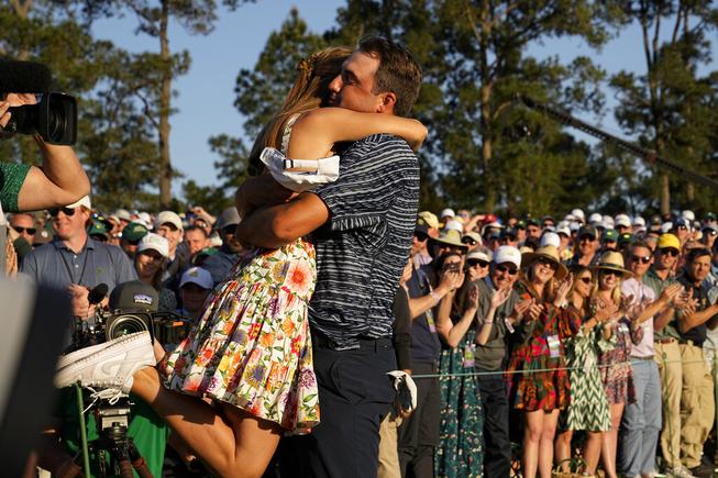 Scottie Scheffler lifts his wife, Meredith Scudder, off her feet after winning the 86th Masters golf tournament on Sunday, April 10, 2022, in Augusta, Ga.