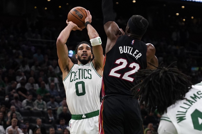 Boston Celtics forward Jayson Tatum (0) shoots over Miami Heat forward Jimmy Butler (22) during the second half of Game 4 Monday, May 23, 2022, in Boston.

