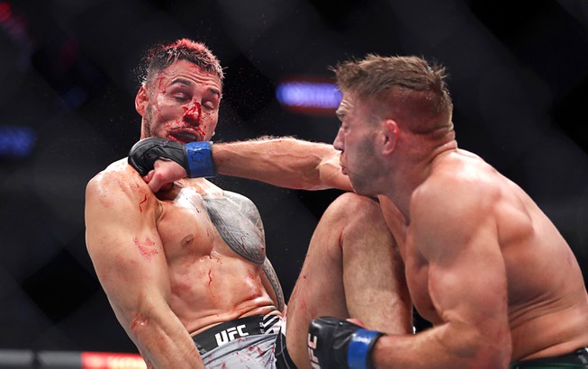 Middleweight fighter Brad Tavares, left, takes a punch from Dricus Du Plessis during UFC 276 at T-Mobile Arena Saturday July 2, 2022. Du Plessis won the bout by unanimous decision. 