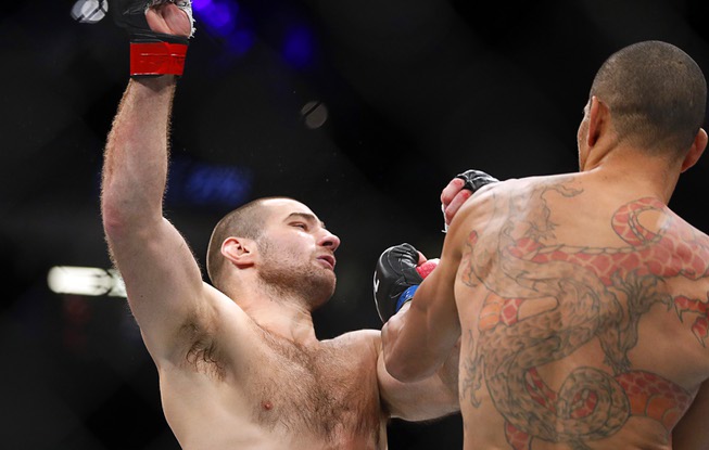 Middleweight fighter Alex Pereia, right, connects with a punch that sends Sean Strickland to the canvas during UFC 276 at T-Mobile Arena Saturday July 2, 2022. Pereia won the bout with a first-round TKO.