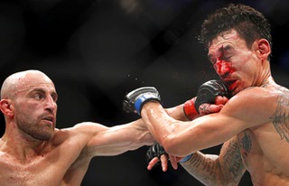 UFC featherweight champion Alexander Volkanovski, left, connects with a punch on Max Holloway during UFC 276 at T-Mobile Arena Saturday July 2, 2022. Volkanovski retained his title by unanimous decision.
