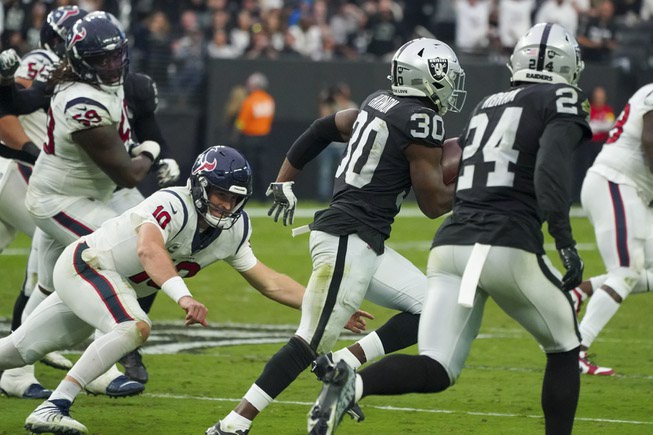 Houston Texans quarterback Davis Mills (10) attempts to tackles Las Vegas Raiders safety Duron Harmon (30) during an NFL football game at Allegiant Stadium Sunday, Oct. 23, 2022.