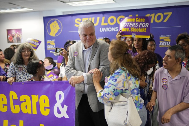 Nevada Gov. Steve Sisolak, center, poses for a photo Oct. 12, 2022, at a campaign event with home care workers at a Service Employees International Union.