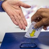 Photo: A voter returns his voting machine activation card