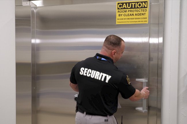 A security guard opens a steel door leading into a vault containing hundreds of collectibles at Collectors Vault, a new company that is making it easier for collectors to store and trade memorabilia, on Oct. 21, 2022, in Delaware. The door is nearly two feet thick and is meant to protect the valuables from harm and thieves.