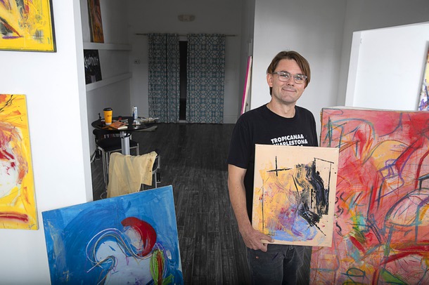 Artist Brian C. Gibson poses with artwork as he sets up for his show titled Boytoy Summer at Inside Style on Main Street Thursday, Nov. 3, 2022. The show runs through Nov. 30.