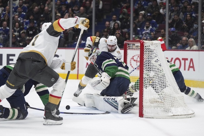 Vancouver Canucks goalie Thatcher Demko, center front, stops Vegas Golden Knights' Brett Howden (21), front left, during first-period action in Vancouver, British Columbia, Monday, Nov. 21, 2022. 


