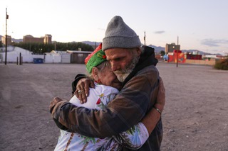 Norma Thornton, 78, left, hugs a homeless man calling himself Charles Dickinson after serving him food in Bullhead City, Arizona Wednesday, Dec. 7, 2022.