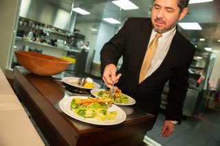 Table captain Anthony Portuondo prepares the table-side Caesar salad for two at Delmonico Steakhouse Thursday Dec. 29, 2022.