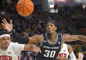 UNLV guard Keyshawn Hall (14) and Utah State forward Dan Akin (30) fight for a rebound during the first half of an NCAA college basketball game Tuesday, Jan. 17, 2023, in Logan, Utah.