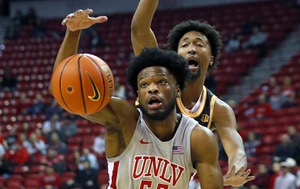UNLV Rebels guard EJ Harkless (55) reaches for a loose ball in front of Wyoming Cowboys forward Jeremiah Oden (25) during the first half of an NCAA basketball game at the Thomas & Mack Center Tuesday, Jan. 24, 2022.