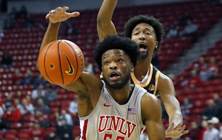 UNLV Rebels guard EJ Harkless (55) reaches for a loose ball in front of Wyoming Cowboys forward Jeremiah Oden (25) during the first half of an NCAA basketball game at the Thomas & Mack Center Tuesday, Jan. 24, 2023.