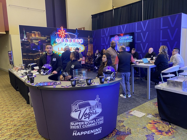 Members of the Las Vegas Super Bowl Host Committee work their booth in Phoenix at the Super Bowl 57 Media Center.
