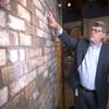 Geoff Schumacher, vice president of exhibits and programs at the Mob Museum, the National Museum of Organized Crime and Law Enforcement, looks over a section of the St. Valentine's Day Massacre wall the Mob Museum in downtown Las Vegas Friday, Feb. 10, 2023.