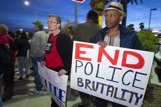 Melissa Finnell, left, and Bernard Walker hold signs during a protest against police violence in front of Clark County School District headquarters on West Sahara Avenue Friday, Feb. 17, 2023. A CCSD police officer was caught on cellphone video slamming a Black teen to the ground and kneeling on his back outside Durango High School last Friday.