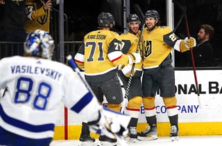 Vegas Golden Knights defenseman Shea Theodore, right, celebrates with Reilly Smith (19) and William Karlsson (71) after scoring past Tampa Bay Lightning goaltender Andrei Vasilevskiy (88) during the first period of an NHL hockey game at T-Mobile Arena Saturday, Feb. 18, 2023.