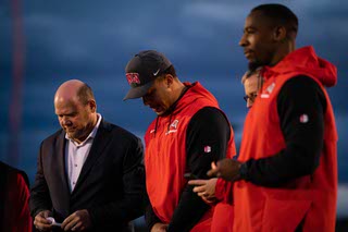 UNLV football offensive coordinator Brennan Marion, right, says a prayer, as head coach Barry Odom and linebacker Elijah Shelton bow their heads, during a memorial at Rebel Park for Ryan Keeler, who died Feb. 20.
