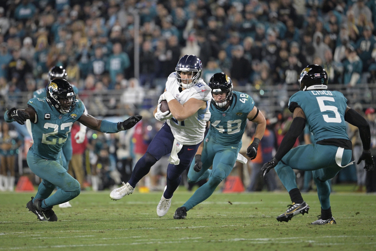 Tennessee Titans tight end Austin Hooper (81) runs after catching a pass  between Jacksonville Jaguars linebacker Chad Muma (48) and safety Andre  Cisco (5) during the first half of an NFL football