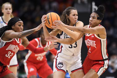 UConn guard Caroline Ducharme (33) holds onto the ball as Ohio State's Cotie McMahon (32) and Taylor Thierry (2) attempt to steal possession during the second quarter of a Sweet 16 college basketball game of the NCAA Tournament in Seattle, Saturday, March 25, 2023.