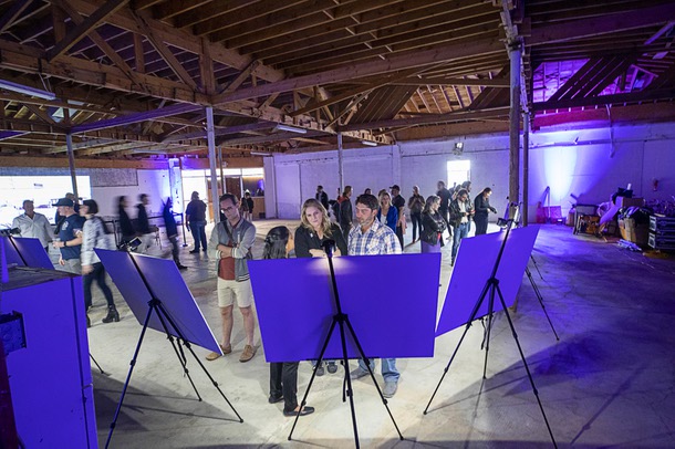 People look over artist renderings and architectural drawings before a sign and marquee lighting ceremony at the Huntridge Theater Friday, April 7, 2023.