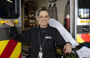 Linda Netski, AMR (American Medical Response) manager of administrative services, poses in the AMR ambulance bay Wednesday, April 12, 2023. Netski started as a nurse at AMR, then Mercy Ambulance, in 1973.