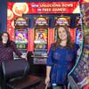 Game designers Kimberly Cohn, left, and Jamie Knight pose by video slot machines in the Light & Wonder showroom Wednesday, April 19, 2023. Cohn's Brainsaw Studio designed the Golden Fire Link games. Knight's Gamblenaut Studio designed the Money Link Power 4 game at right.