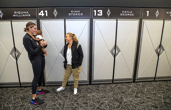 Las Vegas Aces player Las Vegas Aces Cayla George holds her seven-month-old daughter Pearl, as she talks with coach Becky Hammon in the locker room during a tour of the Las Vegas Aces headquarters and practice facility in Henderson Friday, April 28, 2023.