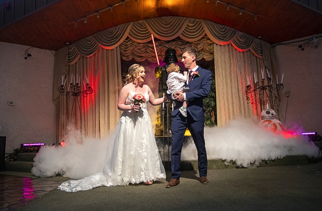 Megan Brooks and Edward Landau-Smith of England get married by an officiate dressed as Darth Vader at the Viva Las Vegas Wedding Chapel Thursday, May 4, 2023. Landau-Smith holds the couple's 16-month-old son Rey. Chapels were busy all day with Star Wars-themed weddings as fans came to get married on May the Fourth (May The Force).