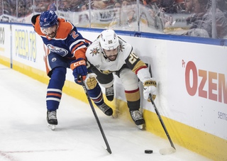 Vegas Golden Knights' Chandler Stephenson (20) and Edmonton Oilers' Evan Bouchard (2) reach for the puck during the first period of Game 4 of a second-round playoff series Wednesday, May 10, 2023, in Edmonton, Alberta. 


