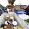 Street vendor Luis Sanchez prepares an elote (corn on the cob with butter, mayonnaise and garnished with cheese) in a cup for customer Miguel Rodriguez in a residential neighborhood in North Las Vegas Wednesday, June 14, 2023. Senate Bill 92, signed by Governor Lombardo last week, legitimizes street vendors across the state, providing them with the necessary permits to operate and grow their small businesses.