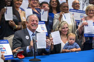 Nevada Governor Joe Lombardo poses with a signed copy of Senate Bill 189 as Nevada State Senate Majority Leader Nicole Cannizzaro and her son Case, 2, look on at right, during a ceremonial signing of the Keeping Kids in School Act, at Ronnow Elementary School Thursday, July 6, 2023. The bill includes a $2 million appropriation for Communities In Schools of Nevada.