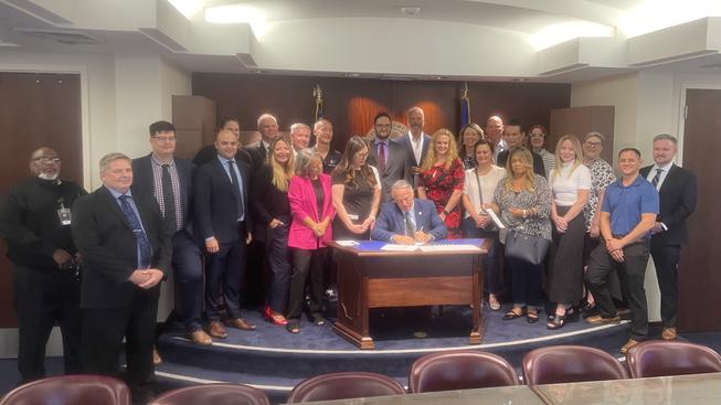 Gov. Joe Lombardo, surrounded by advocates for youths with autism, judges and public defenders, conducts a ceremonial signing of Senate Bill 411, which establishes a statewide diversionary court program for at-risk adolescent youths with autism. The signing was Monday, July 17, 2023, at the Grant Sawyer State Office Building.