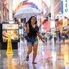 A woman runs through the rain on Fremont Street in downtown Las Vegas Saturday, Aug. 19, 2023.