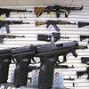 Photo: Assault weapons and hand guns are seen for sale at