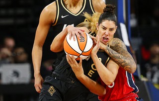 Las Vegas Aces guard Kelsey Plum (10) tries to steal the ball from Washington Mystics center Shakira Austin (0) during the first half of a WNBA basketball game Thursday, Aug. 31, 2023, in Las Vegas.