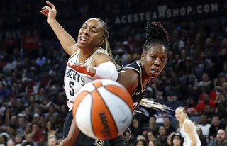 New York Liberty forward Kayla Thornton (5) and Las Vegas Aces guard Chelsea Gray (12) chase  after a ball during the first half of Game 2 in a WNBA basketball final playoff series at Michelob Ultra Arena Wednesday, Oct. 11, 2023.