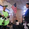 Second grade teacher Maile Rodrigues, dressed as "Sour Grape" for Halloween, speaks to the media as State Superintendent of Public Instruction Jhone Ebert listens during a tour at Clarence Piggott Academy of International Studies Tuesday, Oct. 31, 2023.